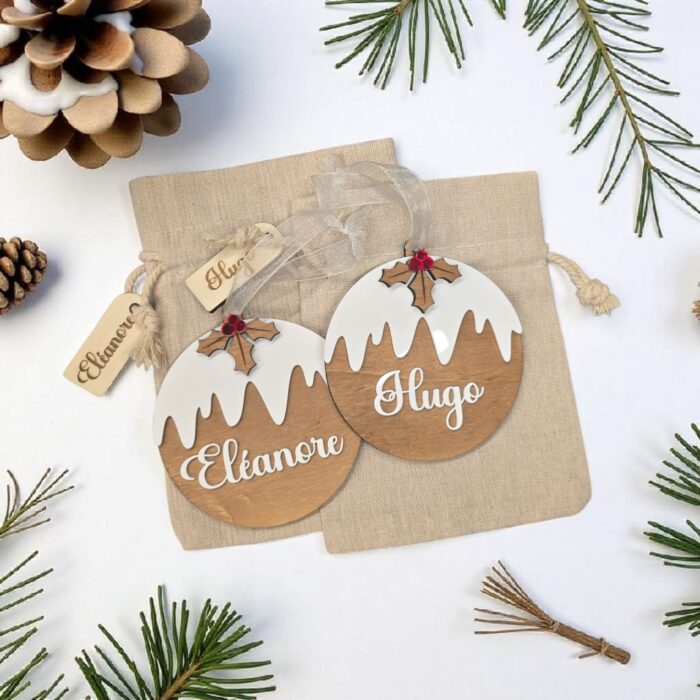 Boules de Noël en bois personnalisée avec le prénom Eléanore et Hugo dans leur pochette cadeau
