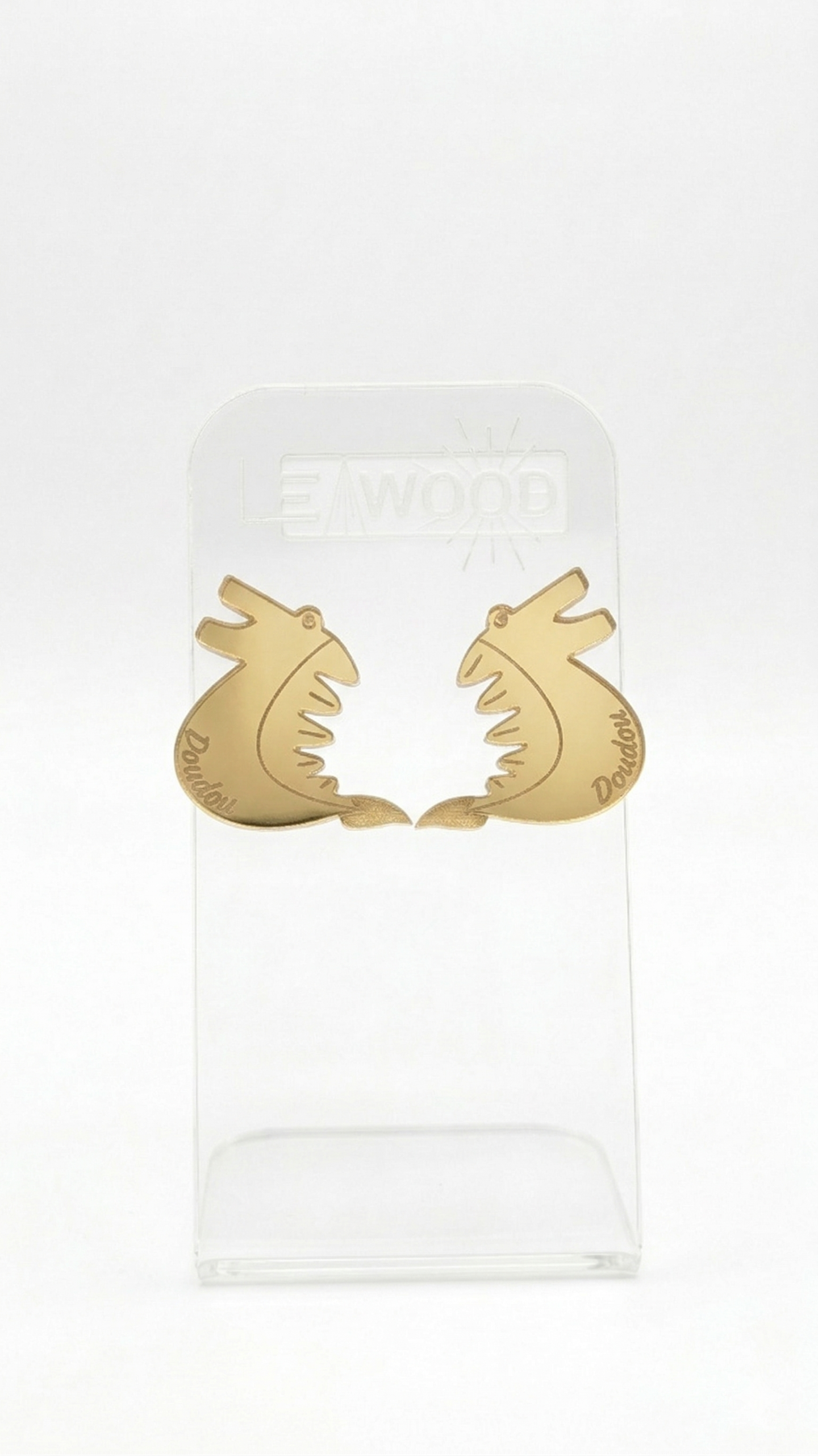 Paire de boucles d'oreilles en forme de dragon pour le Doudou de Mons, couleur doré en acrylique miroir, présentées sur un support transparent gravé LEAWOOD.