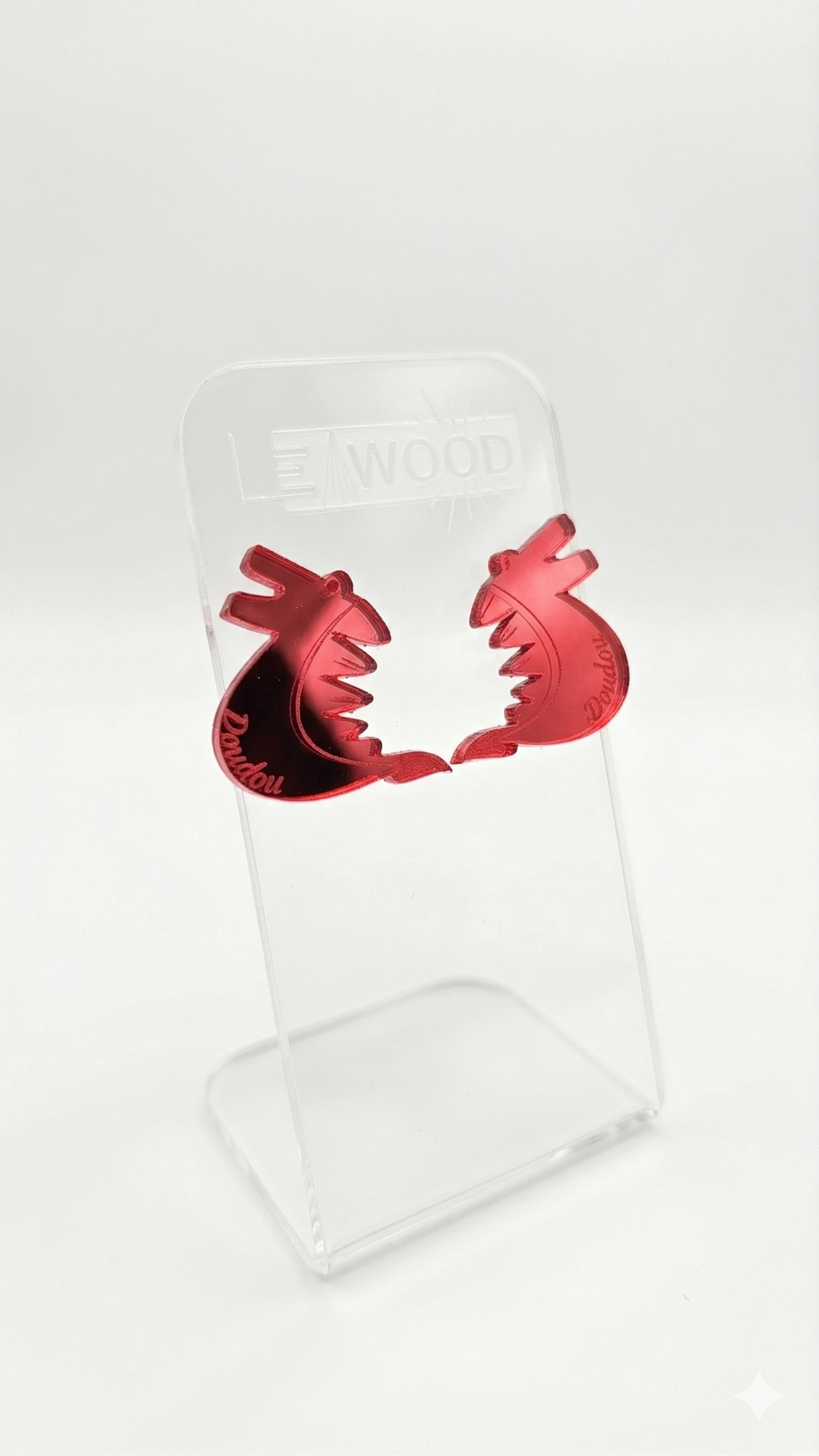 Paire de boucles d'oreilles dragon pour le Doudou de Mons en acrylique miroir rouge, présentées sur un support transparent LEAWOOD.