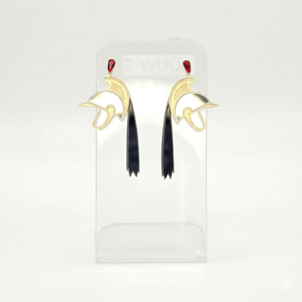 Boucles d'oreilles LEAWOOD en or et argent, représentant le casque de Saint-Georges porté lors de la Ducasse de Mons (Le Doudou), avec pierres rouges et pampilles noires. Vue de face sur présentoir.