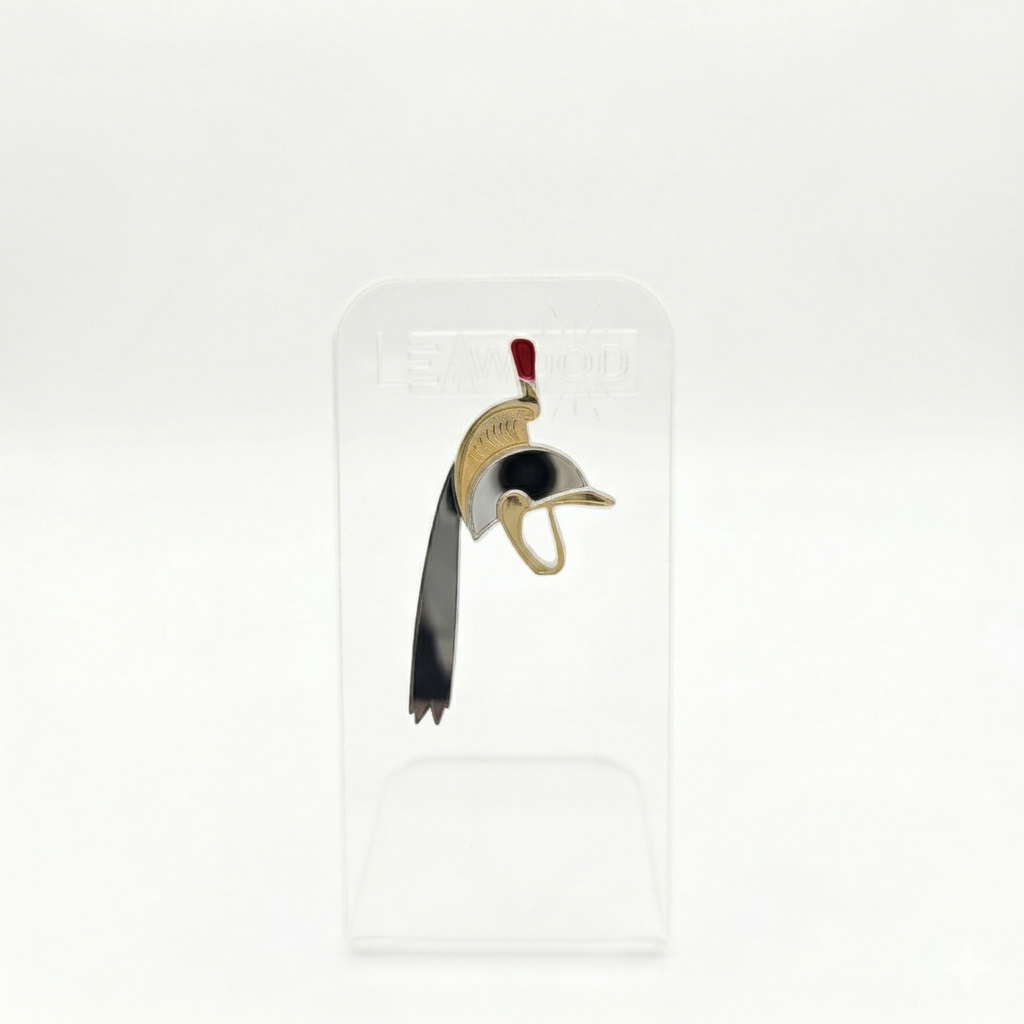 Pin's en acrylique miroir doré et argenté représentant le casque de Saint-Georges du Doudou de Mons, avec plumet rouge, sur présentoir transparent.